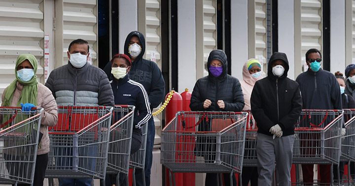 Customers wear face masks to prevent the spread of the novel coronavirus as they line up to enter a Costco Wholesale store.