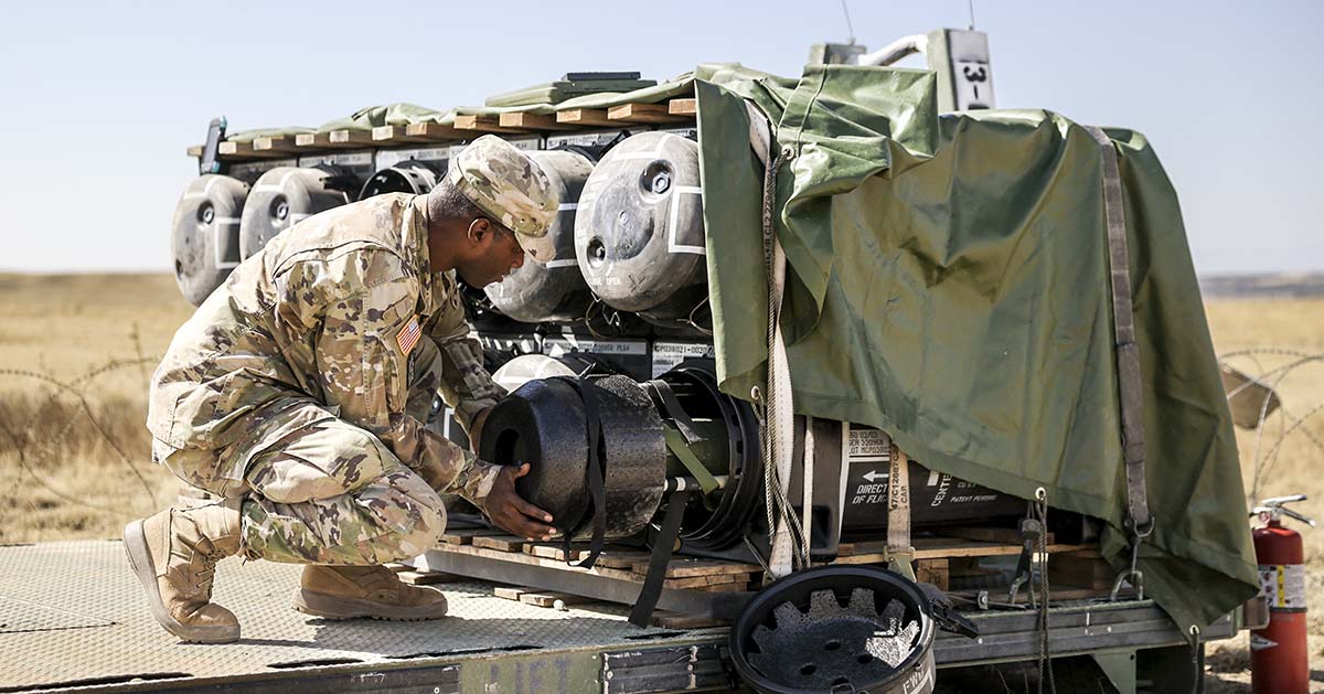 Quinton Dennie with the 2nd Stryker Brigade Combat Team loads a Javelin missile into a transportation container 