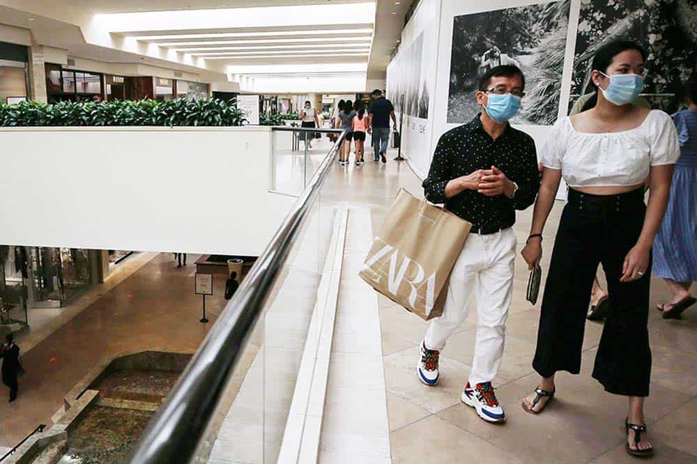 People shopping in an indoor mall with masks on.