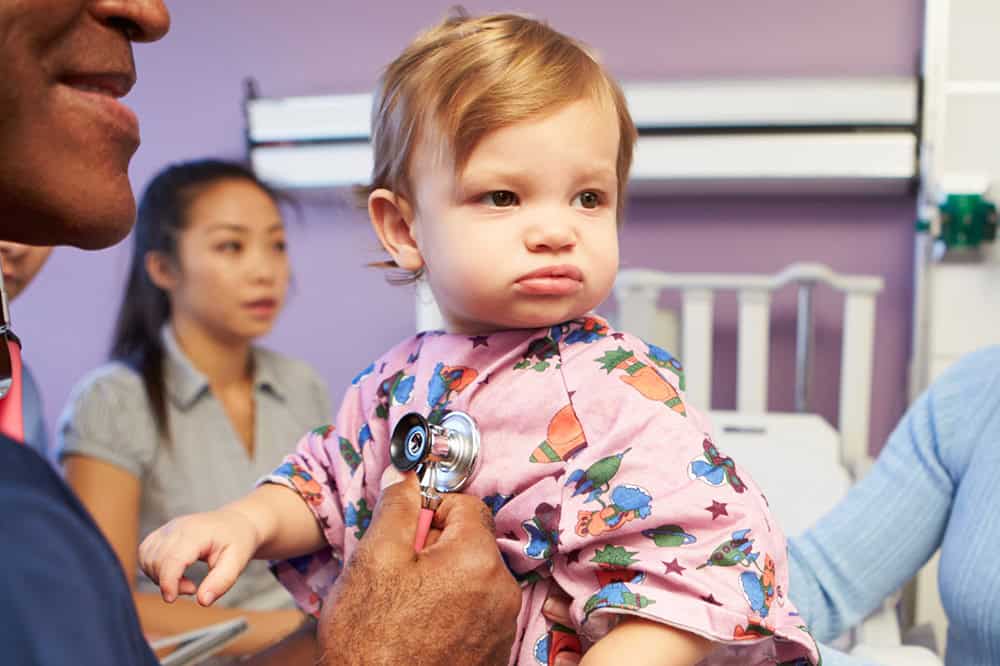 Mother And Daughter With Staff In Pediatric Ward Of Hospital