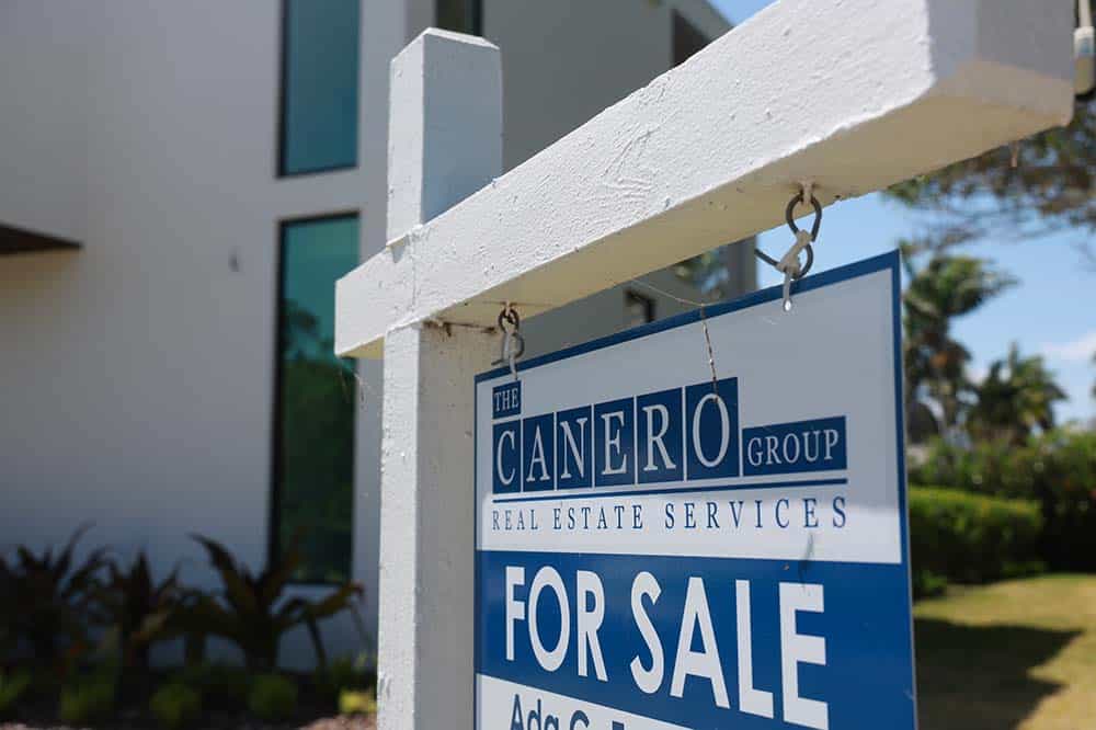 For sale sign in front of a condo building.