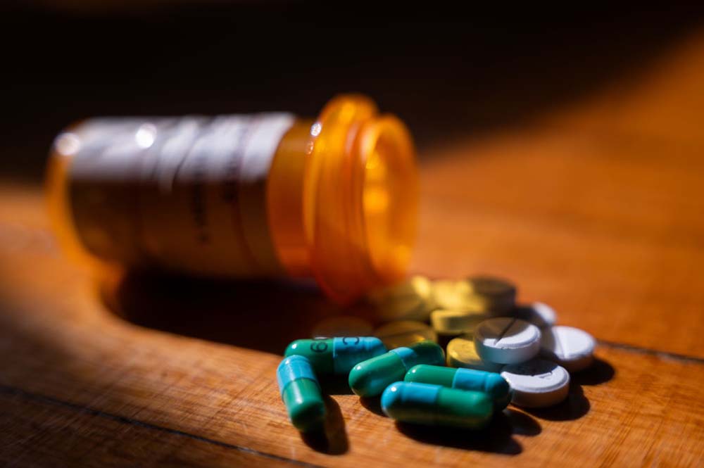 prescription drugs are seen next to a pill bottle