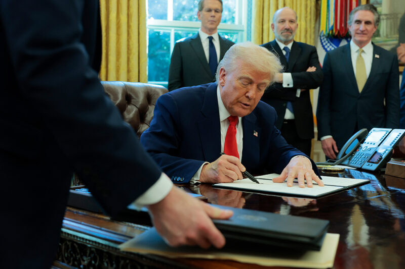 Image of Trump signing a document.