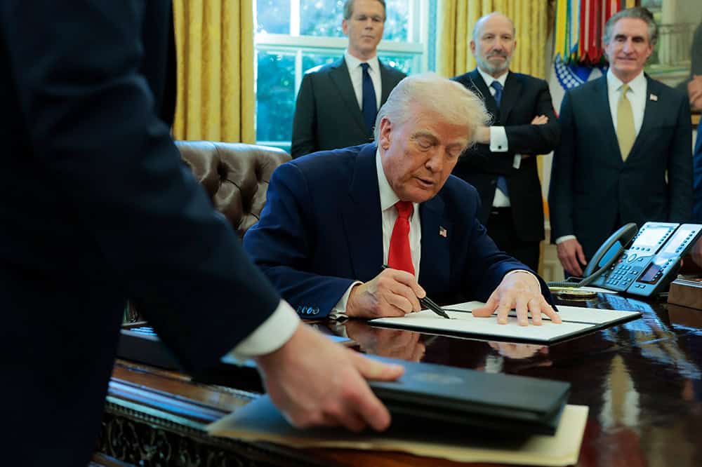 Image of Trump signing a document.