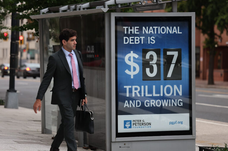 An electronic billboard and a poster display the current U.S. national debt
